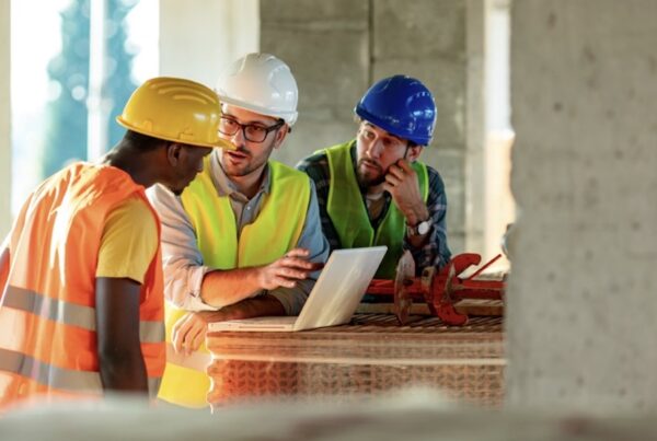 Controlling Your Workers' Compensation Premium Starts With Your Experience Modification Rate (EMR) - constrution men going over plans