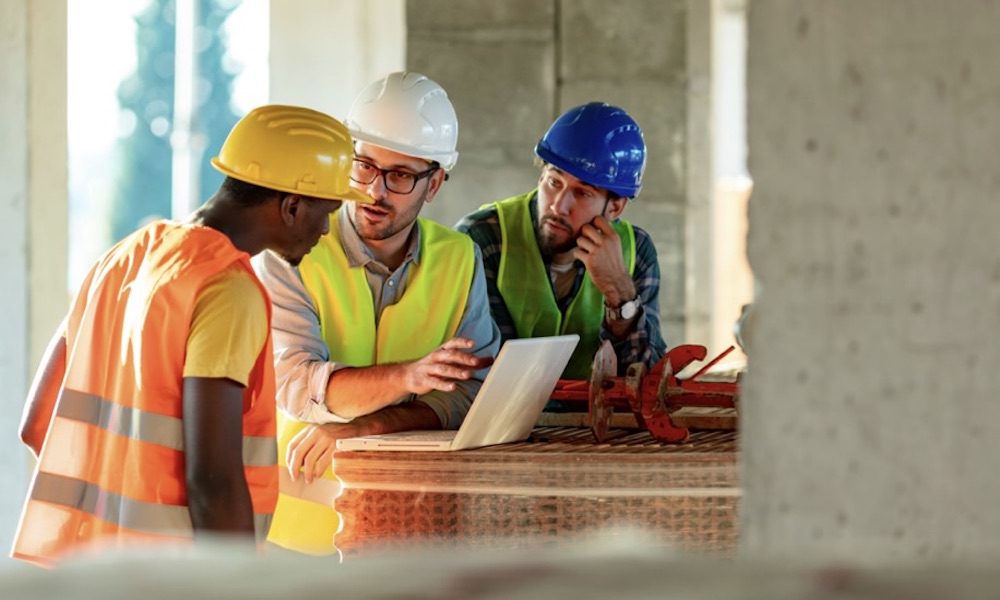 Controlling Your Workers' Compensation Premium Starts With Your Experience Modification Rate (EMR) - constrution men going over plans
